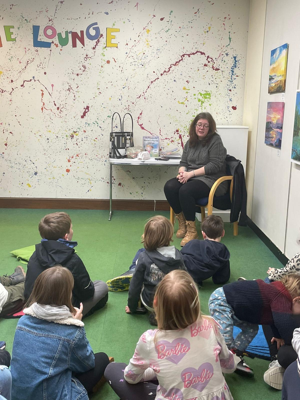 online-university-14 Leah reading a book to a group of children, they are very interested.