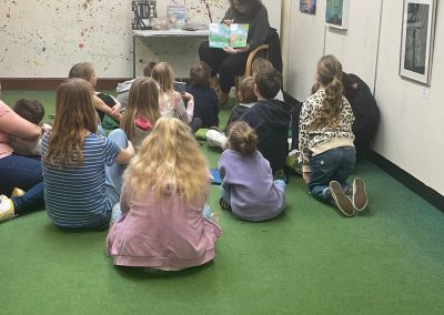 Leah reading her book the princess who wanted to play hide and seek. To a group of young children aged about 3-6 years old. they are all sitting listening intently.
